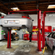 A silver 2003 Porsche 911 is on a lift being repaired.